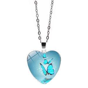Close-up of heart-shaped pendant necklace featuring a blue butterfly artistic design