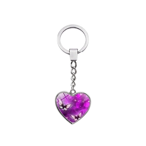 Silver heart keychain with butterfly glass cabochon pendant on white background