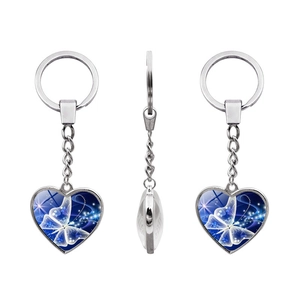 Silver heart keychain with blue glowing butterfly crystal stone in a three-view display