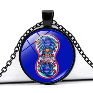 Detail of vintage pendant necklace featuring a purple scorpion totem and meditation icon