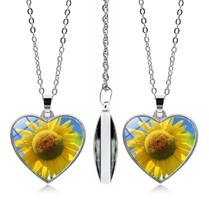 Three-sided view of heart sunflower pendant necklace with silver chain and bright blue sky art