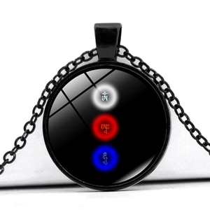 Macro detail of round glass pendant with vibrant mantra symbols on black metal chain