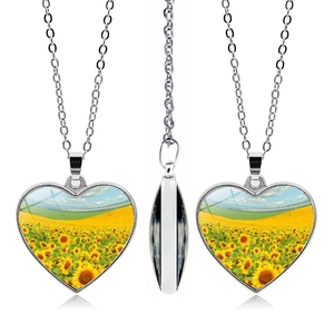 Detail view of heart-shaped sunflower necklaces with silver chains and glass pendants