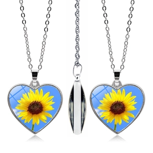Detail view of double-sided heart sunflower pendant with glass cabochon finish