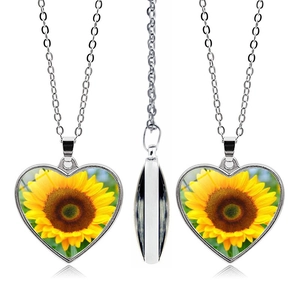 Detail of a sunflower heart pendant necklace featuring a polished silver-tone finish