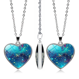 Macro detail of heart-shaped galaxy pendant with nebula pattern and silver chain necklace