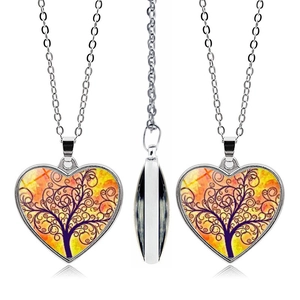 Tre angolazioni della collana con ciondolo a cuore a doppia faccia e motivo albero della vita