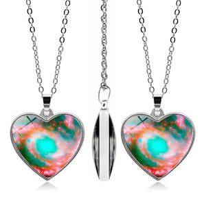 Detailed views of heart-shaped nebula pendant necklace with silver chain from three angles