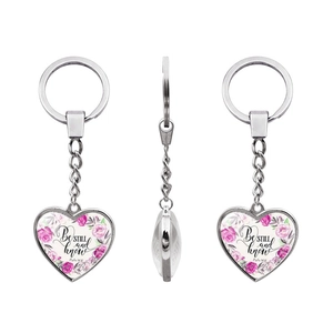 Detail view of heart-shaped keychain with Be still and know floral glass cabochon