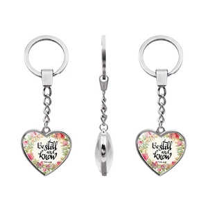 Detailed macro view of heart-shaped metal keychain with Psalm 46:10 floral glass dome