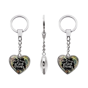 Detail of silver heart keychain featuring In all things Give Thanks inspirational quote