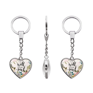 Detailed views showing heart-shaped silver keychain with floral design and soul quote