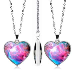 Vue détaillée du pendentif cœur nébuleuse avec chaîne argentée montrant le profil et le verre