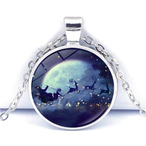 Détail de pendentif de Noël avec le Père Noël et des rennes sous la pleine lune