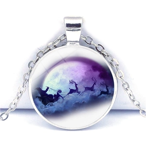 Détail macro du pendentif de Noël argenté avec le Père Noël survolant la pleine lune