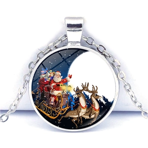 Détail d'un pendentif rond en verre avec le Père Noël sur un traîneau et lune