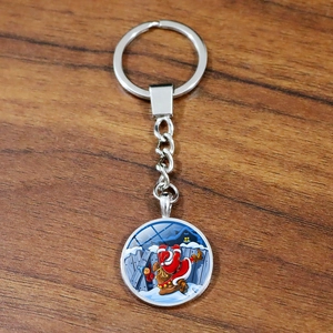 Christmas Santa Claus time gem keychain with silver metal ring on a wooden surface