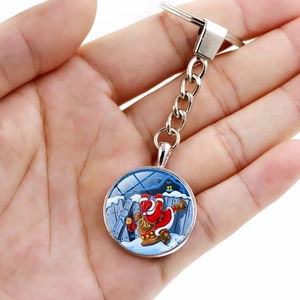 Christmas Santa Claus keychain with silver metal ring and glass dome pendant held in hand
