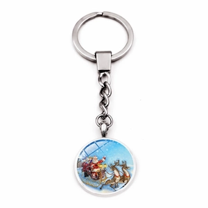 Close-up of Christmas keychain with Santa on reindeer sleigh under glass dome