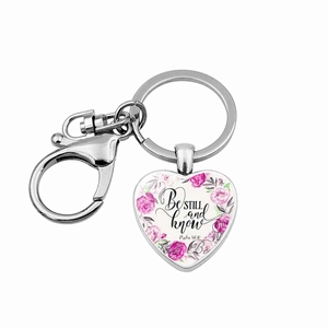 Detail of silver heart keychain featuring Be Still floral quote and lobster clasp buckle