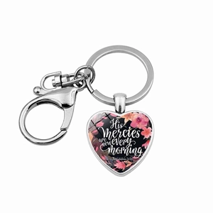 Macro shot of silver heart keychain with pink floral pattern and Bible verse