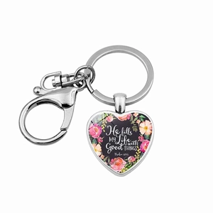 Macro shot of silver heart pendant featuring floral patterns and printed inspirational text