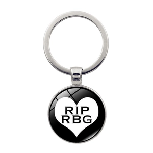 Macro detail of silver memorial keychain with RIP RBG heart design on a polished pendant