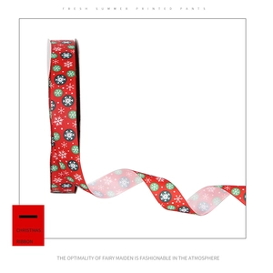 Détail d'un ruban de Noël rouge avec flocons de neige blancs et motifs à pois