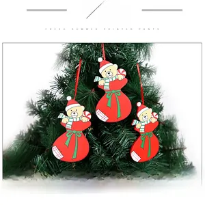 Detailed view of three cute bear Christmas tree ornaments in gift bags with red strings