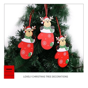 Detailed view of three reindeer glove ornaments hanging on a green Christmas tree