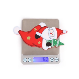 Detailed view of Santa Claus figurine with gold star tree on a digital scale weighing 16g
