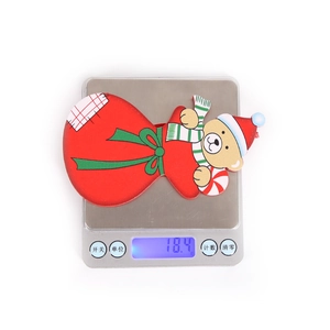 Detail view of a Christmas bear gift bag ornament on a scale weighing 18.4g