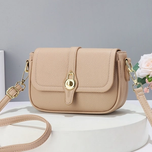 Sac à bandoulière beige chic en cuir grainé avec fermoir rotatif doré sur un support