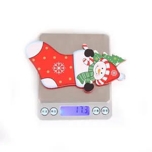 Detailed view of wooden snowman Christmas stocking pendant weighing 17.3g on a scale