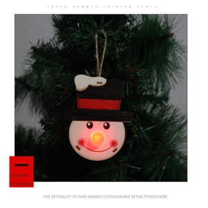 Makro-Detail von Holz-Schneemann-Weihnachtsschmuck mit leuchtend roter LED-Nase am Baum