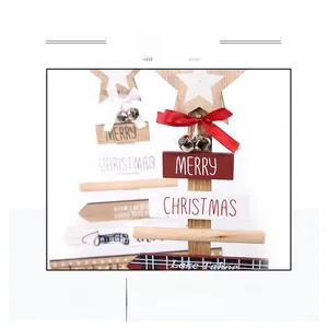 Nahaufnahme von Weihnachtsbaum aus Holz mit Stern, roter Schleife und Glocke