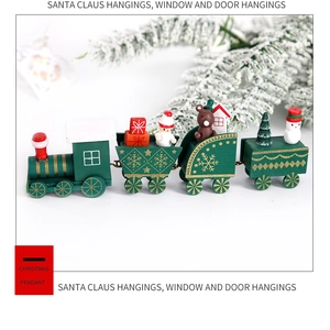 Dettaglio del trenino natalizio in legno verde con figurine e mini scatole regalo