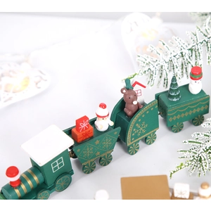 Dettaglio di un trenino di Natale in legno verde con pupazzi di neve e confezioni regalo