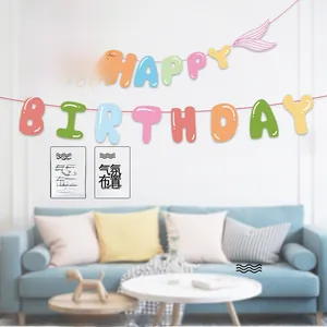 Mermaid happy birthday banner with colorful letters and cartoon graphics hanging on wall