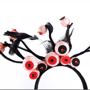 Detail of Halloween eyeball headband with red veins, black feathers and glitter eye details