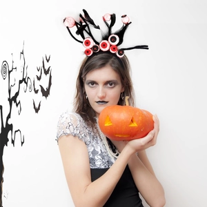 Halloween headband with creepy bloodshot eyeballs and black feathers on a model