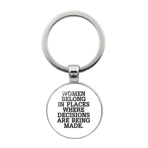 Detail of silver keyring featuring 'Women belong in places where decisions are being made' quote