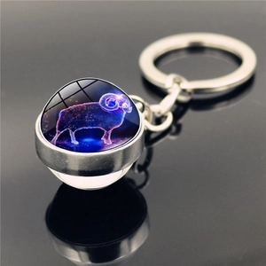 Detail of Aries constellation glass ball keychain with silver metal base and star design