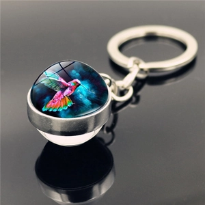 Close-up of double-sided hummingbird crystal glass ball pendant with silver keychain