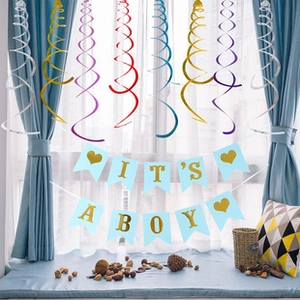 Λεπτομέρεια διακόσμησης baby shower με χρυσό πανό IT'S A BOY και πολύχρωμες σπείρες