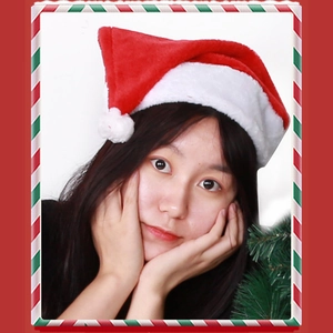 Close-up of classic red plush Christmas hat with white faux fur trim and pom-pom on model