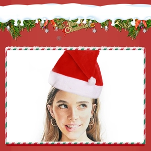 Close-up of classic plush Christmas hat with white pom-pom on festive red background