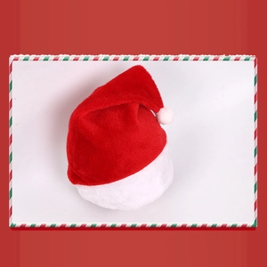 Flat lay of a plush red Christmas hat with soft white faux fur trim and pom-pom detail