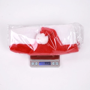 Detailed view of a plush Christmas hat on a digital scale showing 44.5g weight