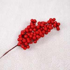 Détail macro de baies rouges artificielles sur fond en peluche blanche pour Noël